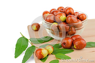 Ripe jojoba fruits in a bowl on a wooden tabletop. Chinese date fruit Stock Photo