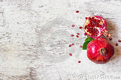 Ripe juicy pomegranate fruit on white wooden rustic background Stock Photo