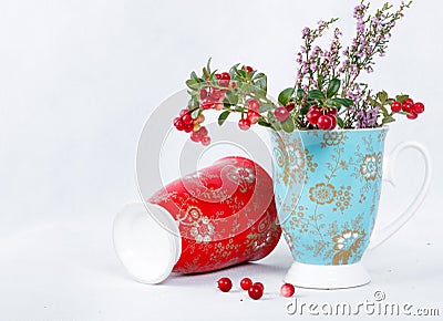 Ripe lingonberries and varicolored cups with ornament Stock Photo