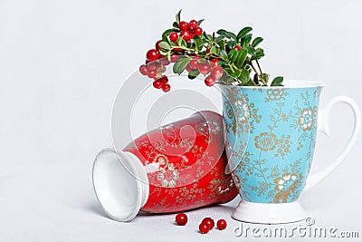 Ripe lingonberries and varicolored cups with ornament Stock Photo