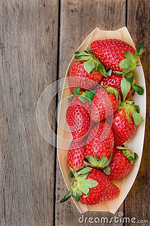Ripe organic strawberries in birchbark bowl on dark wood background, top view, summer, healthy food Stock Photo