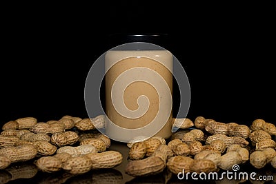 Ripe peanuts in husk and jar with peanutbutter Stock Photo