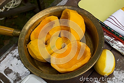 Ripe peeled pumpkin, cut into pieces, lies in a copper pan for making jam Stock Photo