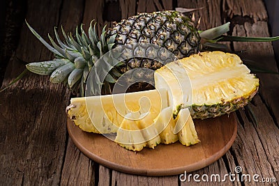 Ripe pineapple and pineapple slices on a wooden background tropical fruits Stock Photo