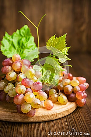 Ripe pink grapes with leaves Stock Photo