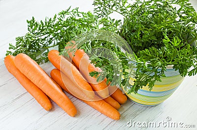 Ripe raw carrot with foliage on wooden table background Stock Photo