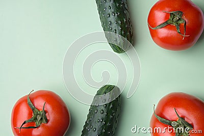Ripe raw organic tomatoes cucumbers on light lettuce green background. Balanced diet vegan superfoods healthy lifestyle vitamins Stock Photo