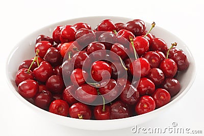 Ripe red cherries in a large white ceramic bowl Stock Photo