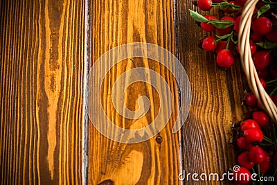 Ripe red dogrose in a basket on a wooden Stock Photo
