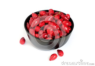 Ripe red dogwood berries in black round bowl isolated on white background front view close-up Stock Photo