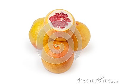 Partly cut red grapefruit lies on the other whole grapefruits Stock Photo