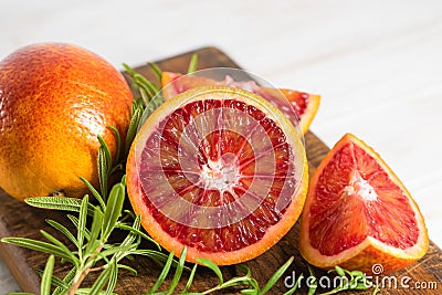 Ripe red oranges on wooden background. Sliced ripe juicy Sicilian Blood oranges on white wooden background Stock Photo