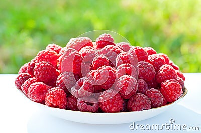 Ripe red raspberries in a plate. Berries close-up. Healthy food Stock Photo