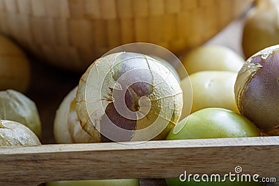 Ripe tomatillo Mexican husk tomato, Physalis philadelphica, Vegetable physalis in wooden tray on white table Stock Photo