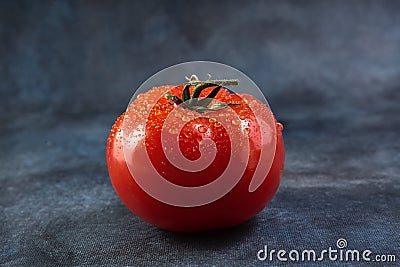 Ripe tomato with drops views on grunge background. Stock Photo