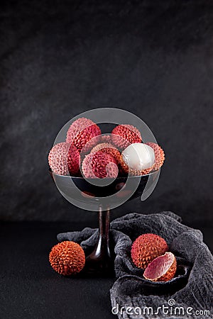 Ripe, vermilion exotic lichees decorated on a slate plate kitchen table background with napkin Stock Photo