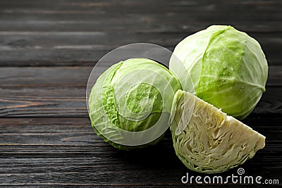 Ripe white cabbage with water drops on black wooden table Stock Photo