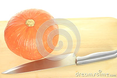 Riped orange pumpkin and silver kitchen knife Stock Photo