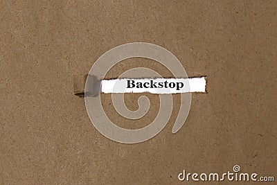 Ripped brown manilla envelope revealing the word backstop on white paper Stock Photo