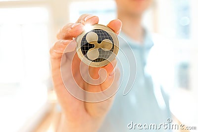 Ripple cryptocurrency coin held by a man Editorial Stock Photo