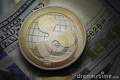 Ripple XRP Coin cryptocurrency lying on a hundred dollars bills background.Electronic money exchange concept.Macro Shot Editorial Stock Photo