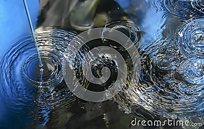 Ripples of Serenity: Breaking Drops on Calm Waters Stock Photo