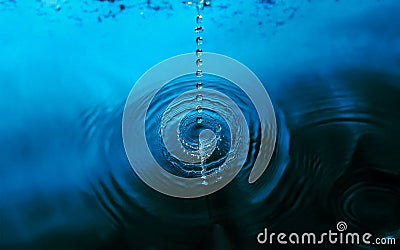 Ripples of Serenity: Breaking Drops on Calm Waters Stock Photo