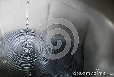 Ripples of Serenity: Breaking Drops on Calm Waters Stock Photo