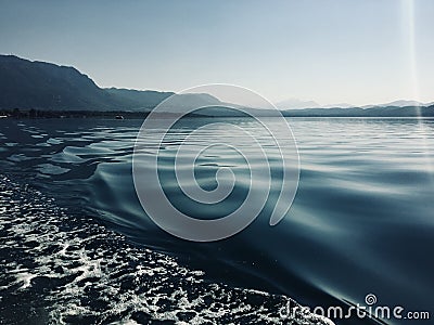 Ripples In The Wake Of A Pontoon Boat At Sunrise On a Lake in Turkey Stock Photo