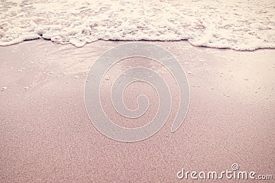 Ripples wave and bubbles foam sea on sand beach Stock Photo