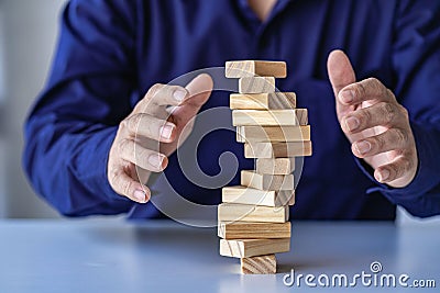 risk management concepts Hands trying to protect the crumbling wooden blocks block tower businessman Stock Photo