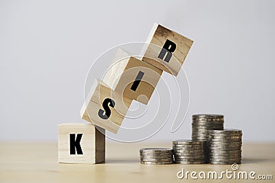 Risk wooden block cube falling to money coin stacking for financial risk assess management and business analysis concept Stock Photo
