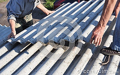 Risks of Asbestos Roofs, Asbestos Roof Removal. Asbestos removal roof works. House with old, danger asbestos roof tiles repair Stock Photo