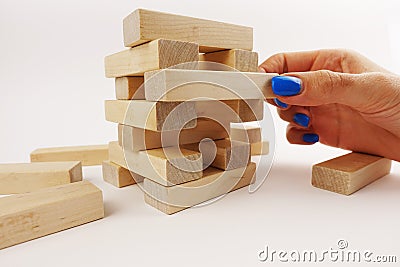 Risky moves concept with woman hand tacking an wooden piece from a tower Stock Photo