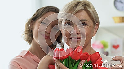 Ritratto del derivato adulto e della madre che tengono i tulipani, celebrante giorno delle donne stock footage Ritratto del derivato adulto e della madre che tengono i tulipani, celebrante giorno delle donne stock footage