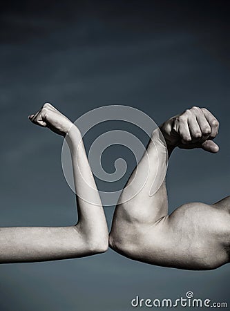 Rivalry, vs, challenge, strength comparison. Muscular arm vs weak hand. Vs, fight hard.Competition, strength comparison Stock Photo