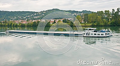 River barge cursing on the Rhone river on a cloudy day Stock Photo