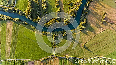 River bend surrounded by fields from bird`s eye view. Stock Photo