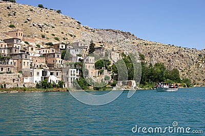 River boat in front of Sunken village at Firat River Editorial Stock Photo