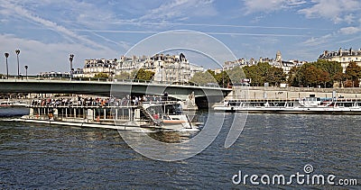 A River Boat full of Tourists making its way down the River Seine Editorial Stock Photo