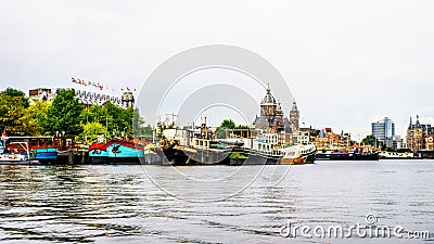 River boats moored in the busy harbor of the city of Amsterdam Stock Photo