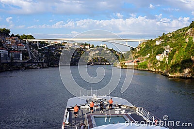 A river, a bridge, roofs of houses and a large white pleasure cruise boat in the light of the setting sun Editorial Stock Photo