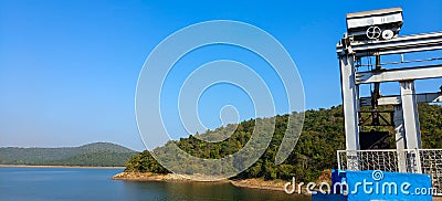 River with clear blue sky and green forest background, summer scene with hydro electric power plant Stock Photo