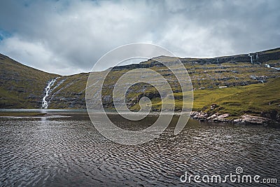 River delta with black sand beach, rocks and high cliffs in Faroe islands, close to village Saksun in Faroese island Stock Photo