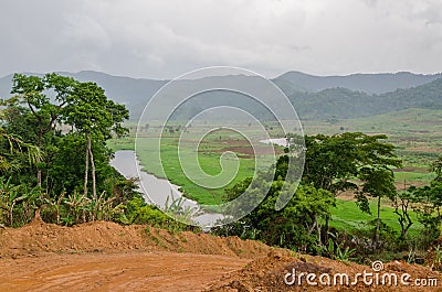 River and dirt road with mountains and lush vegetation at Ring Road in Cameroon, Africa Stock Photo