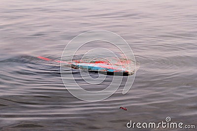 River fishing boat sunk in the river. Sunken boat in dirty water. Vintage old colorful wooden boat sunk in the harbor. Stock Photo