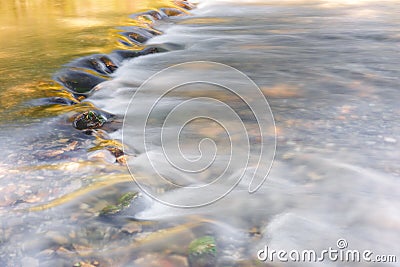 River flowing through golden and green foliage Stock Photo