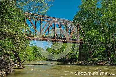 A river flowing underneath a train trestle Stock Photo