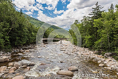 River through forest near the White Mountains, a bridge in background Stock Photo