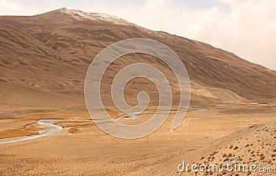 River Panj Pyandzh between Tajikistan and Afghanistan. Pamir Highway road carved in the left. Pamir Mountains Stock Photo